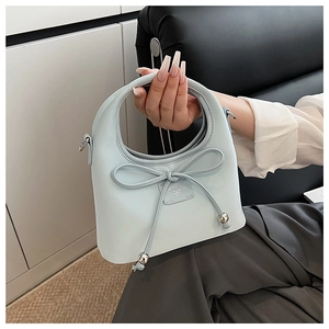 Détail du sac à main bleu clair avec un grand nœud et une poignée ronde intégrée
