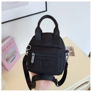 Detail of waterproof nylon crossbody bag with dual handles and removable strap