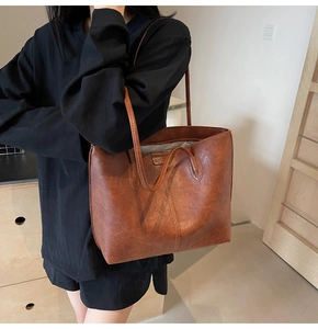 Brown vintage leather tote bag shown on model for high capacity daily commute style