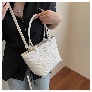 Detail of the white woven texture and detachable metal hooks on the tote bag