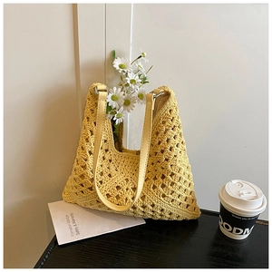Gros plan du sac à bandoulière en crochet jaune clair avec des anses en similicuir PU