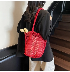 Detail of red hollow knit beach tote bag with thick twisted rope shoulder straps