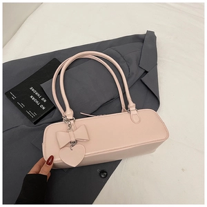 Detail of light pink baguette bag with 3D bow, heart pendant and dual shoulder straps