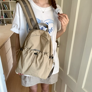 Detail of light khaki nylon backpack with adjustable drawstring pocket for outdoor travel