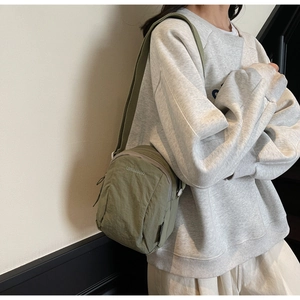Détail du sac bandoulière en nylon vert clair avec sangle réglable sur un mannequin