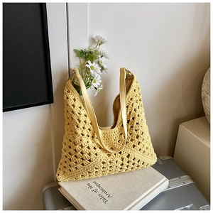 Détail du sac cabas en tricot ajouré jaune avec motifs floraux au crochet et bandoulière