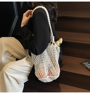 Macro detail of white hand-woven knit tote bag with minimalist hollow mesh pattern design
