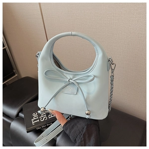 Détail du sac croissant bleu clair avec cordon nœud, chaîne métal et poignée ronde