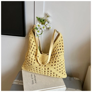 Détail d'un sac fourre-tout au crochet jaune clair avec maille et bandoulière cuir