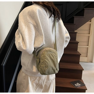 Détail du sac bandoulière en nylon vert olive avec double fermeture éclair et sangle réglable