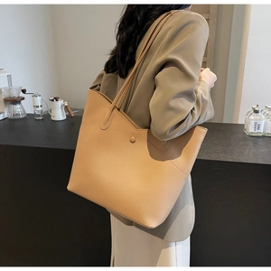 Detail of light brown tote bag with lychee texture being worn over the shoulder
