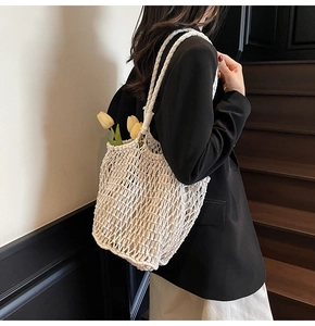 Detail of white crochet knit tote bag with mesh pattern and woven shoulder straps