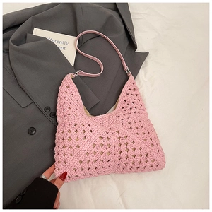 Détail du sac hobo en crochet rose avec texture florale évidée et bandoulière en cuir