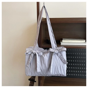 Close-up of lilac quilted nylon tote bag with vertical pleats and cute bow details