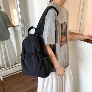 Detail view of durable nylon backpack with adjustable side drawstrings and padded straps