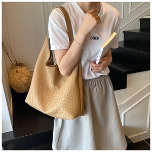 Detail der großen Khaki-Canvas-Hobo-Tasche mit Fischgrätenmuster getragen von Model