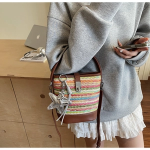 Detail of colorful woven bucket bag featuring silver starfish charm and leather handle
