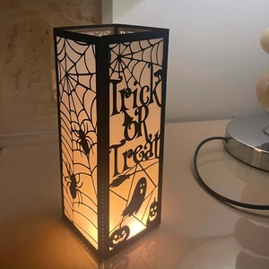 Detail of Trick or Treat Halloween lantern with spider web patterns and warm LED glow