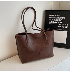 Detailed view of dark brown PU leather texture and vertical stitching on the tote bag