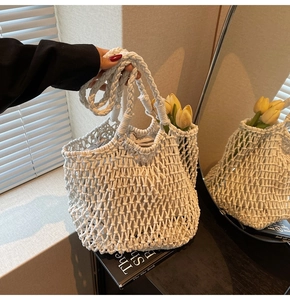 Detail of white crochet tote bag with mesh weave pattern and floral summer decoration