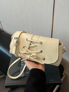 Creamy white rectangular shoulder bag with lace-up detail and silver eyelets