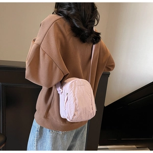 Détail du sac à bandoulière en nylon violet clair avec sangle réglable et fermeture éclair