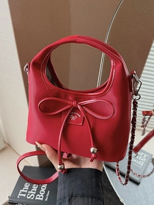 Sac à main élégant en cuir rouge avec nœud décoratif et bandoulière en chaîne amovible
