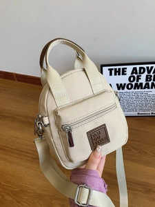 Cream waterproof nylon crossbody bag with adjustable strap and front zipper pocket