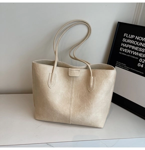 Detailed macro view of the cream tote bag showing premium lychee texture and vertical stitching