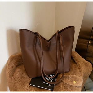 Close-up of large dark brown tote bag showing lychee pattern leather and magnetic buckle