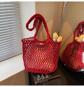 Close-up of red crochet mesh tote bag with thick knit straps and white fabric liner