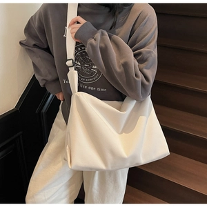 Detail of white corduroy tote bag showing striped texture and wide adjustable strap