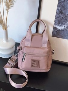 Waterproof nylon mini crossbody bag in dusty pink with adjustable shoulder strap