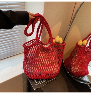 Macro detail of red knitted hollow tote bag with floral fabric lining and braided handles