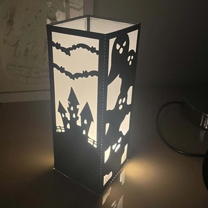Detailed macro view of laser-cut Halloween candle holder with ghost and castle patterns