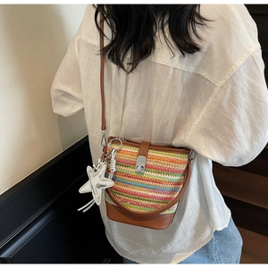 Detailed view of the multi-color woven bucket bag with leather strap and silver star charm