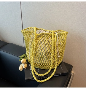 Detail of yellow hollow knit tote bag with beige drawstring lining and crochet texture