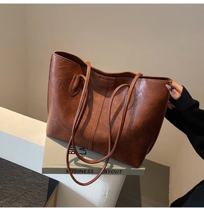 Detail of vintage brown leather tote bag with premium texture on decorative book