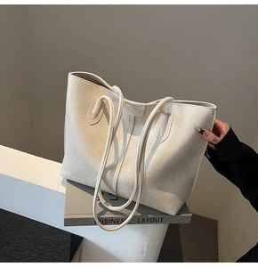 Detail shot of cream white faux leather tote bag with soft texture and long handle strap
