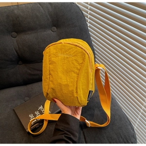 Détail du sac bandoulière en nylon jaune gingembre avec texture plissée et sangle réglable