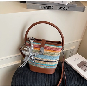 Detail of multi-color woven bucket bag with brown leather trim and starfish charm accessory