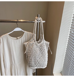 Detailed texture of hand-woven cream hollow macrame beach tote bag with chunky handle