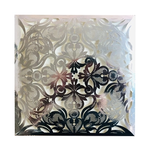 Macro shot of laser-cut floral wedding invitation with metallic rose gold lace finish