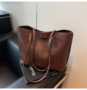 Close-up of deep brown tote bag with premium leather texture and stitching details