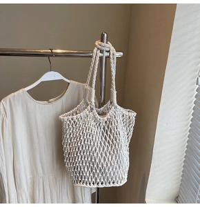 Detailed close-up of ivory macrame tote bag with handmade hollow weave and sturdy handles
