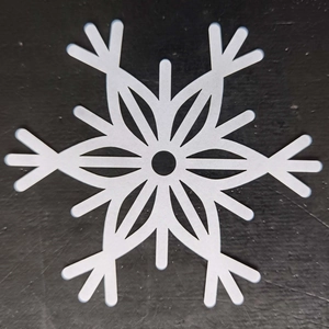Macro detail of laser-cut white snowflake coaster decoration for Christmas party decor