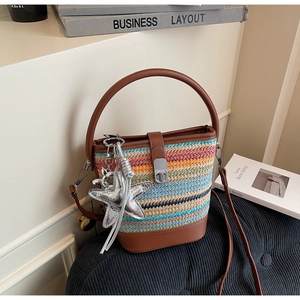Detail of color-block woven bucket bag with brown leather strap and starfish charm