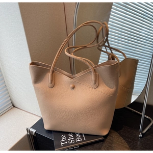 Close-up of beige large tote bag showing high-quality lychee texture and slim straps