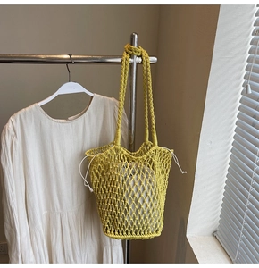 Detail of hand-woven hollow knit tote with mustard yellow mesh and drawstring liner