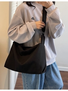 Minimalist black canvas crossbody tote bag with wide shoulder strap for daily commuting